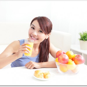 Cheerful woman drinking an orange juice