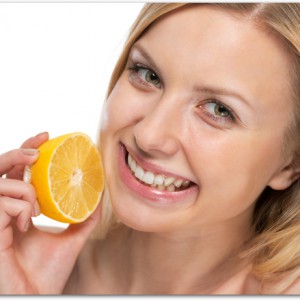 Portrait of smiling young woman with lemon